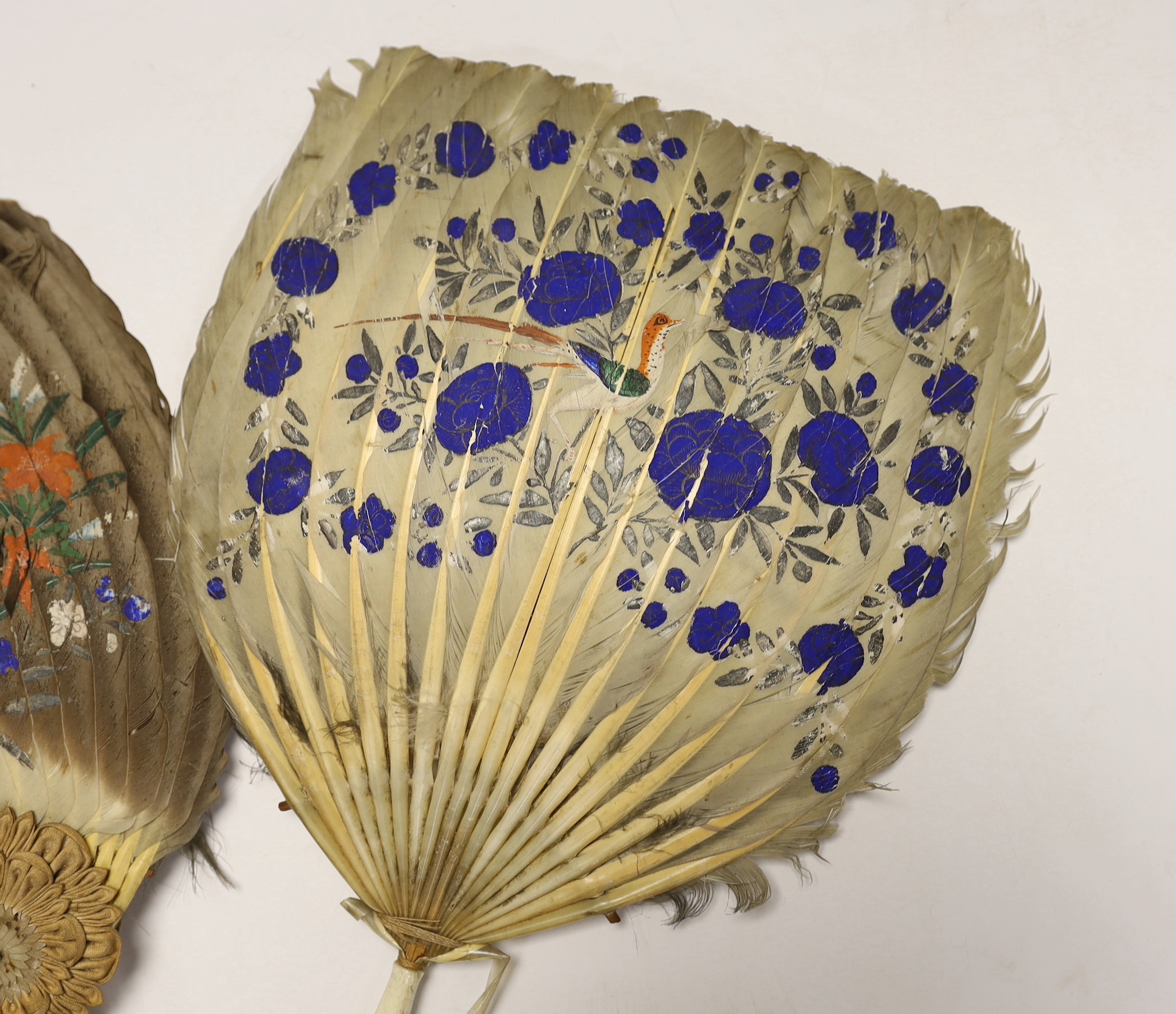 Two feather and bone handled Regency feather fans, the feathers hand painted with Chinese figures one side and flowers the other, one fan has silk rosettes with mother of pearl and feather ornamentation to the top of the